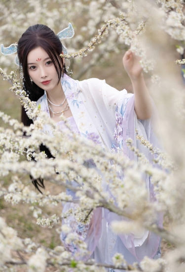 花海深处仙子立，紫纱轻舞映白樱。她指尖轻触春枝，是人间四月天里，最温柔的一抹惊鸿。