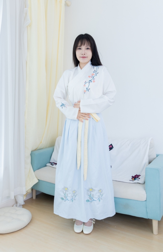 素衣如雪映春光，淡蓝裙裾绣花香。现代闺阁藏古韵，一颦一笑皆是诗，汉服之美在日常。