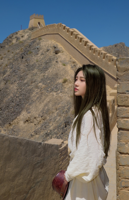 白裙踏古道，风起长城间，一缕清影诉尽千年苍茫与温柔。